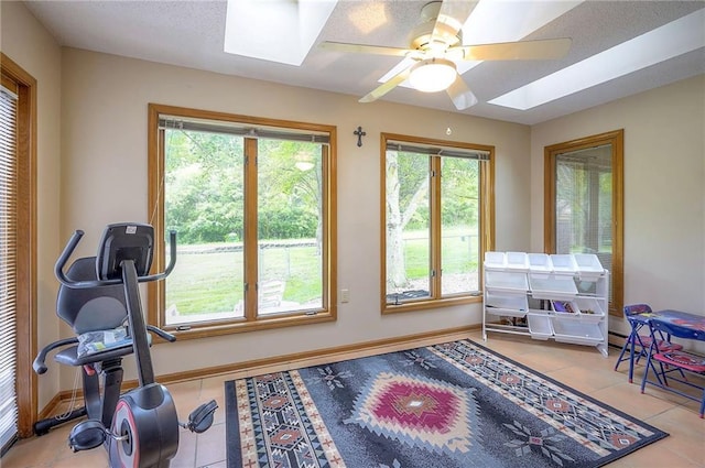 8309 E 190th St, Belton, MO 64012 - exercise room featuring a skylight, plenty of natural light, ceiling fan, and tile patterned flooring
