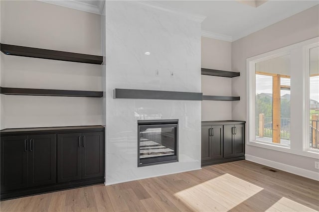 14278 S Houston St, Olathe, KS 66061 - unfurnished living room with crown molding, light wood-type flooring, a tiled fireplace, healthy amount of natural light, and baseboards
