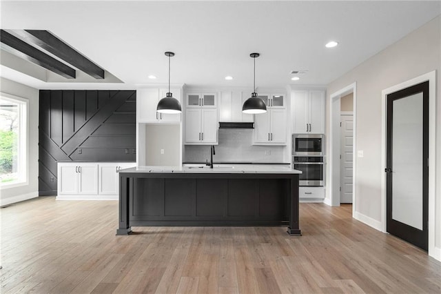 14278 S Houston St, Olathe, KS 66061 - kitchen featuring stainless steel microwave, white cabinets, decorative backsplash, light wood-style floors, and recessed lighting