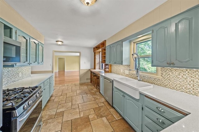 2306 Red Bridge Ter, Kansas City, MO 64131 - kitchen with appliances with stainless steel finishes, a sink, light countertops, and stone tile flooring