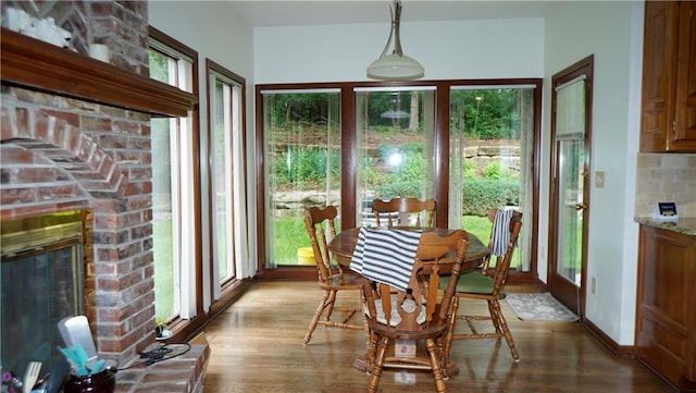 5500 NW 62nd St, Kansas City, MO 64151 - dining space featuring light wood finished floors, a brick fireplace, and baseboards