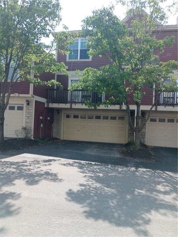 15829 W Robinson St, Overland Park, KS 66223 - townhome / multi-family property featuring an attached garage, stone siding, and driveway