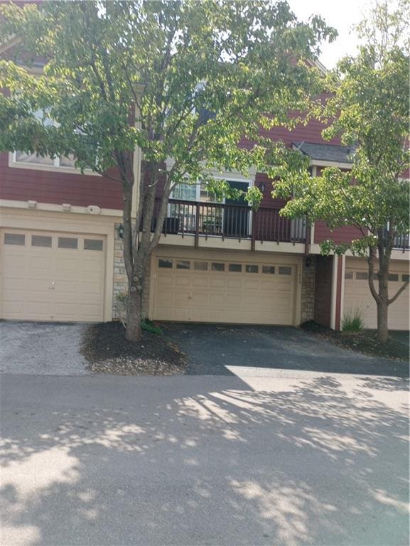 15829 W Robinson St, Overland Park, KS 66223 - townhome / multi-family property with stone siding, asphalt driveway, and an attached garage