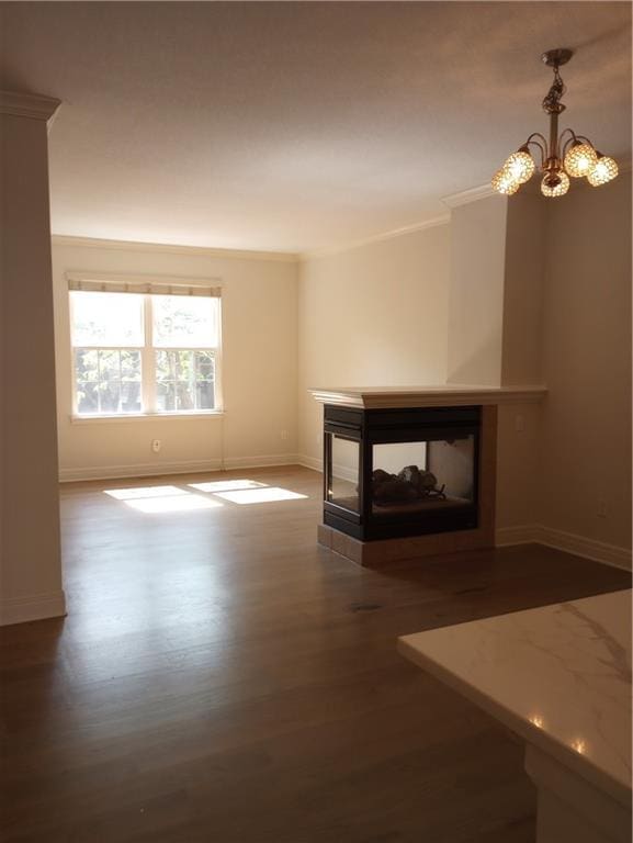 15829 W Robinson St, Overland Park, KS 66223 - unfurnished living room featuring a multi sided fireplace, wood finished floors, baseboards, a chandelier, and crown molding