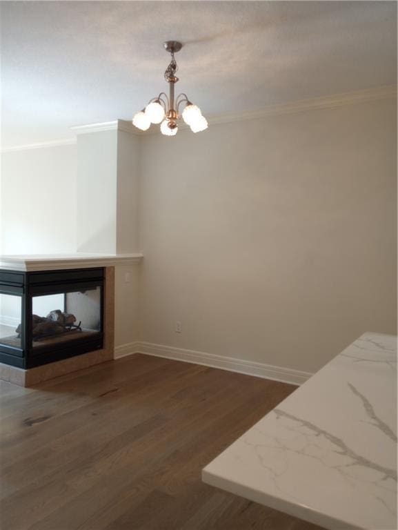 15829 W Robinson St, Overland Park, KS 66223 - unfurnished dining area with ornamental molding, a chandelier, dark wood finished floors, baseboards, and a multi sided fireplace