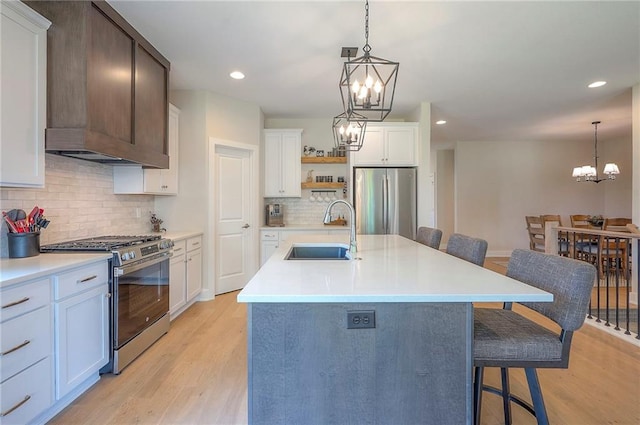 24129 W 95th St, Lenexa, KS 66227 - kitchen with appliances with stainless steel finishes, a sink, a chandelier, open shelves, and a kitchen breakfast bar