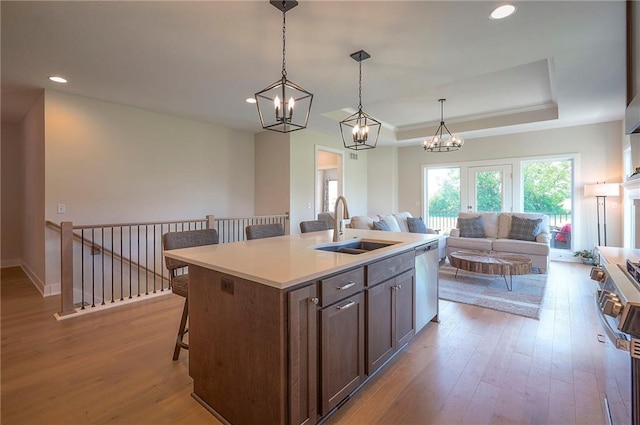 24129 W 95th St, Lenexa, KS 66227 - kitchen with a sink, appliances with stainless steel finishes, a breakfast bar area, a raised ceiling, and hardwood / wood-style flooring