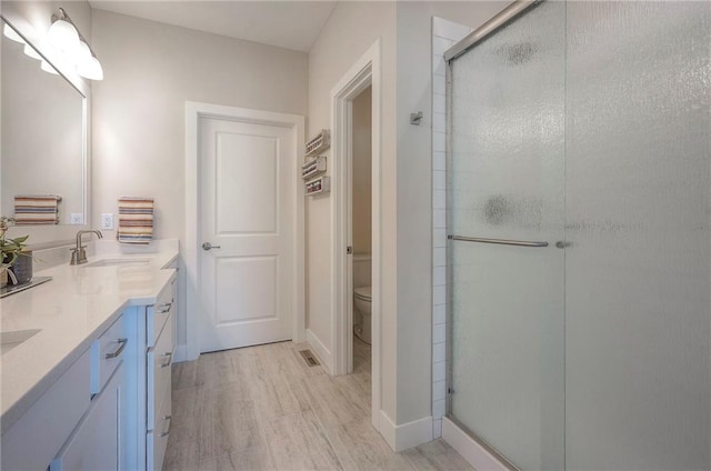 24129 W 95th St, Lenexa, KS 66227 - bathroom featuring double vanity, a stall shower, toilet, and baseboards