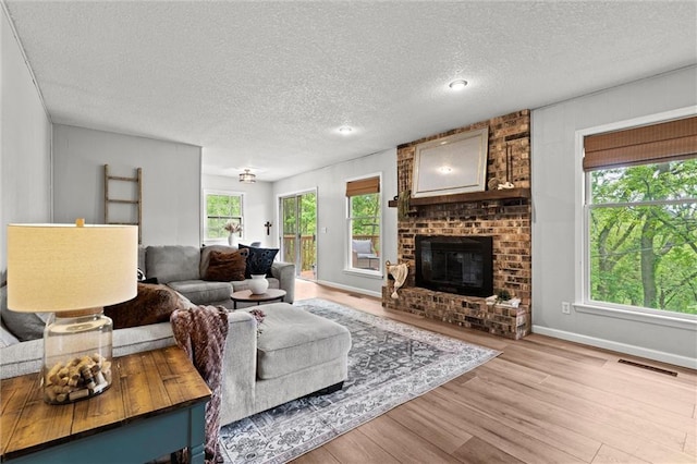 6525 County Line Rd, Shawnee, KS 66216 - living room featuring wood finished floors, a textured ceiling, and a fireplace