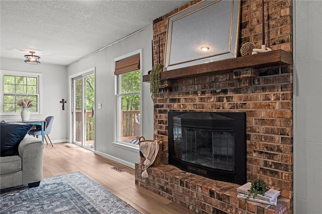 6525 County Line Rd, Shawnee, KS 66216 - living room with wood finished floors, a textured ceiling, and a brick fireplace