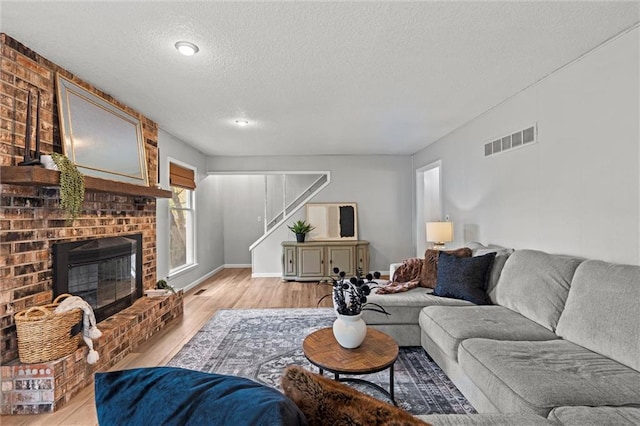 6525 County Line Rd, Shawnee, KS 66216 - living area with a textured ceiling, stairway, light wood-type flooring, and a brick fireplace