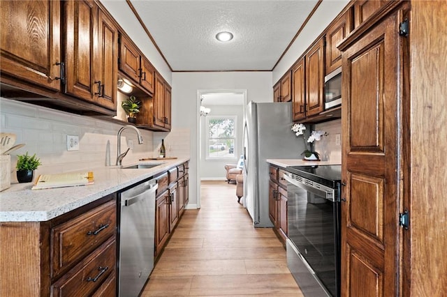 6525 County Line Rd, Shawnee, KS 66216 - kitchen with appliances with stainless steel finishes, a textured ceiling, light wood-style flooring, and tasteful backsplash