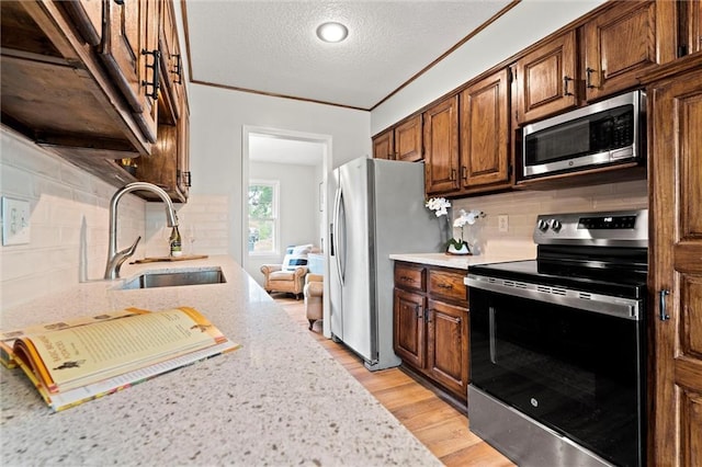 6525 County Line Rd, Shawnee, KS 66216 - kitchen with stainless steel appliances, tasteful backsplash, light stone countertops, light wood-type flooring, and a textured ceiling