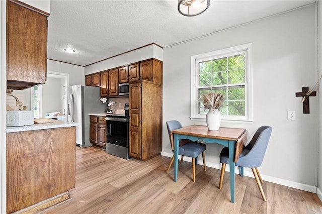 6525 County Line Rd, Shawnee, KS 66216 - kitchen featuring appliances with stainless steel finishes, light countertops, light wood finished floors, and a textured ceiling