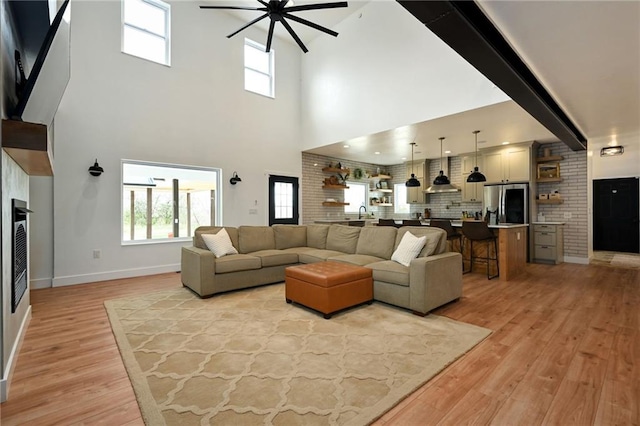 24905 W 57th St, Shawnee, KS 66226 - living area with a ceiling fan, light wood-style flooring, a towering ceiling, and baseboards
