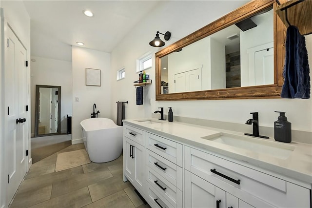 24905 W 57th St, Shawnee, KS 66226 - full bath with double vanity, a freestanding bath, recessed lighting, and tile patterned floors