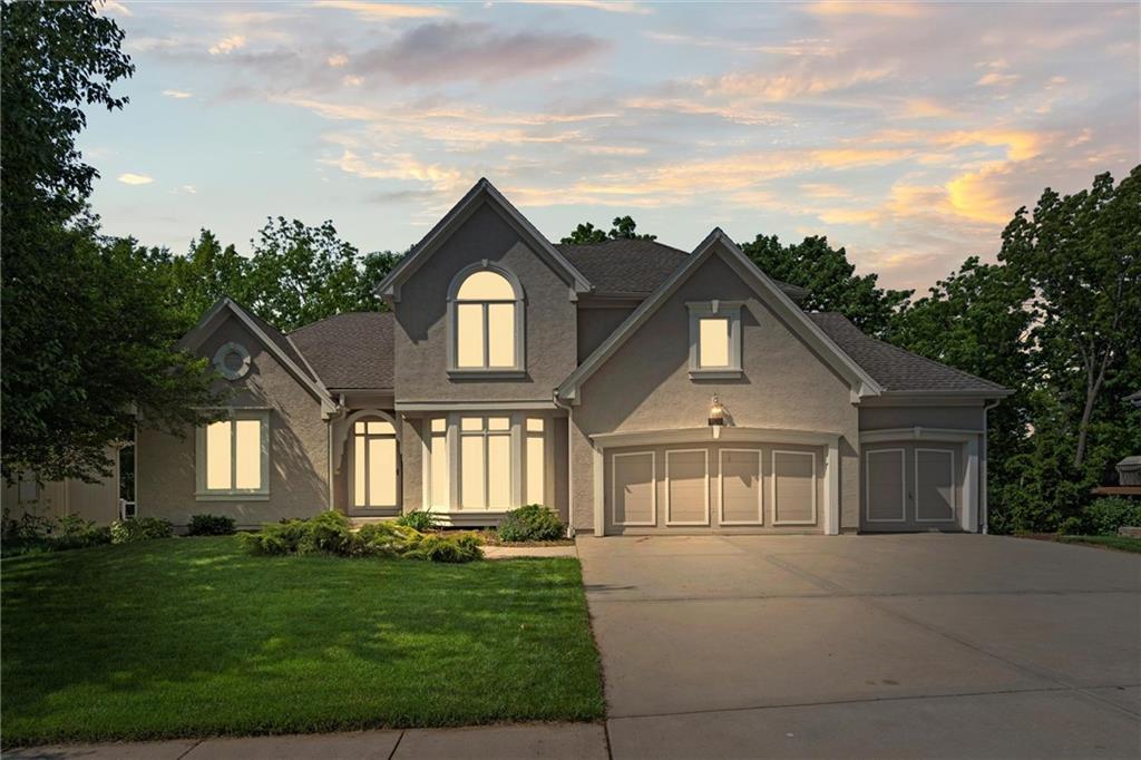 14913 W 72nd St, Shawnee, KS 66216 - view of front of property featuring concrete driveway, a yard, stucco siding, and a garage