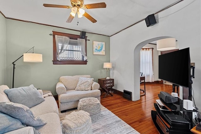 1405 W 40th St, Kansas City, MO 64111 - living room with arched walkways, wood finished floors, and a ceiling fan