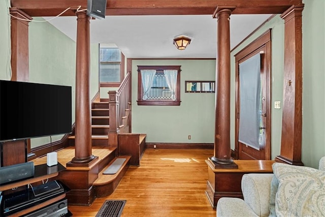 1405 W 40th St, Kansas City, MO 64111 - living area featuring decorative columns, wood finished floors, and stairs