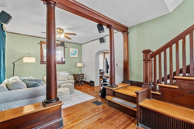 1405 W 40th St, Kansas City, MO 64111 - living area featuring arched walkways, a ceiling fan, wood finished floors, and stairs
