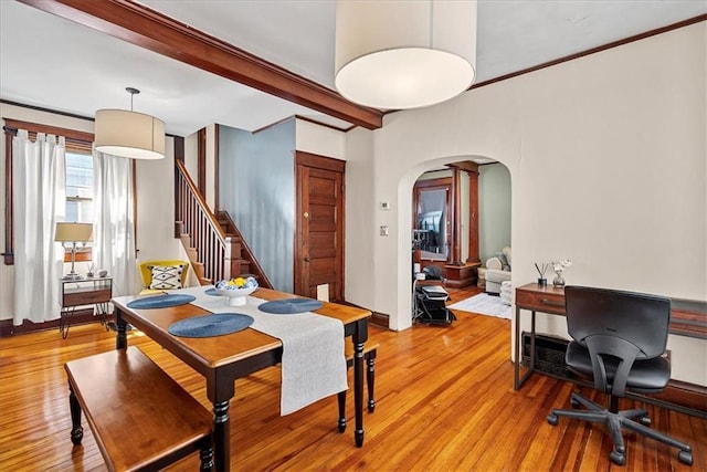 1405 W 40th St, Kansas City, MO 64111 - dining space featuring arched walkways, light wood finished floors, beamed ceiling, and stairs