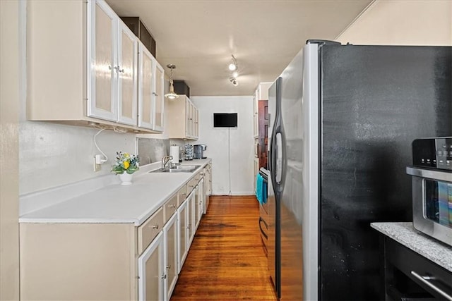 1405 W 40th St, Kansas City, MO 64111 - kitchen with stainless steel fridge, dark wood-type flooring, light countertops, glass insert cabinets, and white cabinetry