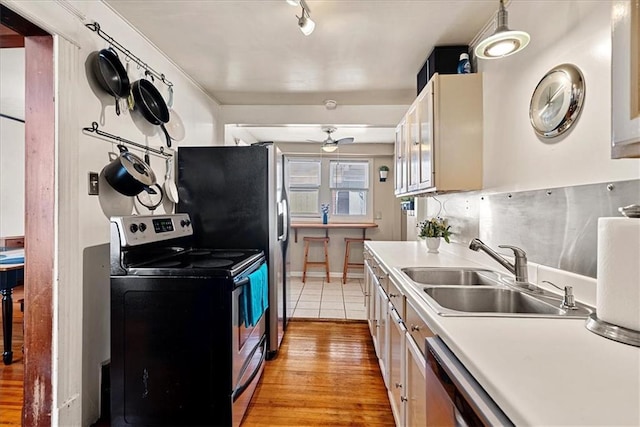 1405 W 40th St, Kansas City, MO 64111 - kitchen featuring stainless steel appliances, light wood-type flooring, a ceiling fan, and light countertops