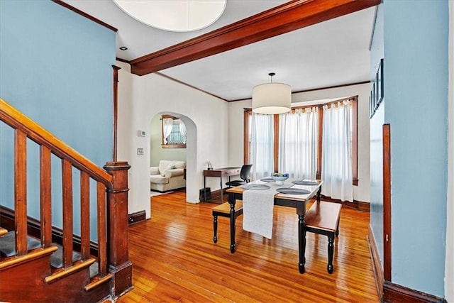 1405 W 40th St, Kansas City, MO 64111 - dining area featuring arched walkways, wood finished floors, stairs, ornamental molding, and beamed ceiling