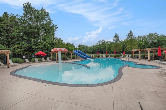 1515 Fox Run Ln, Raymore, MO 64083 - community pool with a pergola, a patio, view of wooded area, and a water slide