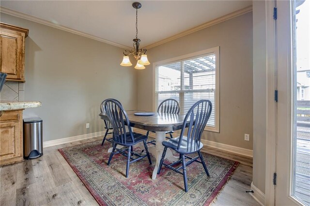 2208 SW Hawk View Rd, Lees Summit, MO 64082 - dining room with light wood-type flooring, a chandelier, baseboards, and crown molding