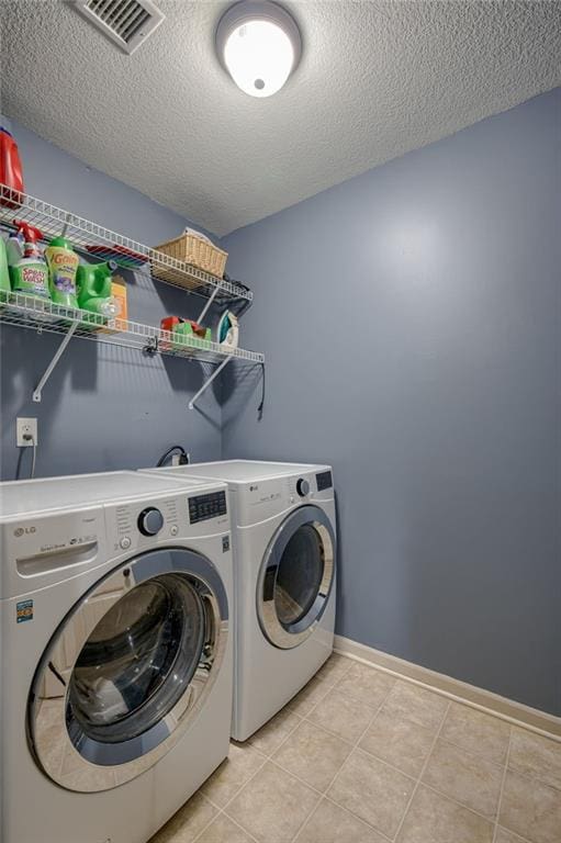 2208 SW Hawk View Rd, Lees Summit, MO 64082 - laundry room featuring washing machine and dryer, a textured ceiling, light tile patterned floors, and baseboards