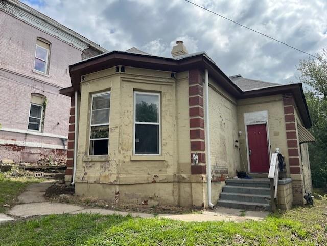 515 N 11th St, Saint Joseph, MO 64501 - view of side of property with a chimney and brick siding