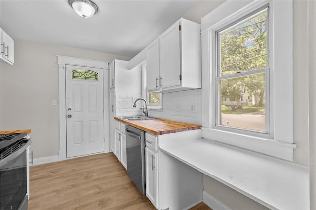 2100 S Scott Ave, Independence, MO 64052 - kitchen featuring stainless steel dishwasher, a sink, stove, wooden counters, and white cabinets
