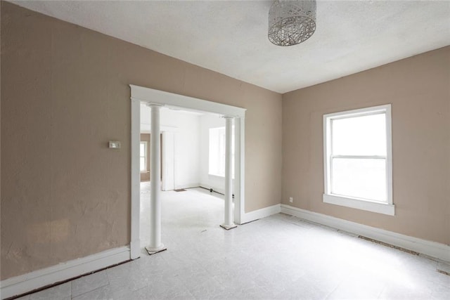 1129 Metropolitan Ave, Kansas City, KS 66103 - empty room featuring baseboards, ornate columns, and tile patterned floors