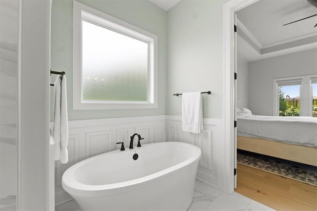 9412 Aurora St, Lenexa, KS 66220 - full bath featuring connected bathroom, marble look tiles, a wainscoted wall, a soaking tub, and a decorative wall