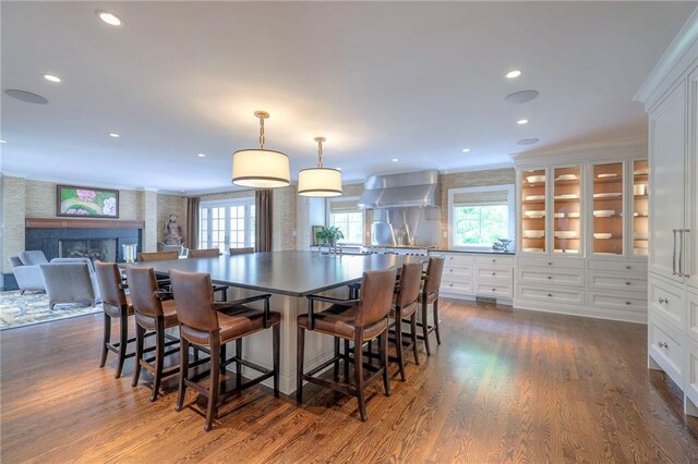 1055 W 54th St, Kansas City, MO 64112 - dining room featuring dark wood-type flooring, plenty of natural light, recessed lighting, a fireplace, and crown molding