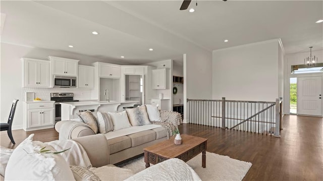 1300 Melissa Ct, Kearney, MO 64060 - living area with dark wood-style floors, recessed lighting, crown molding, a ceiling fan, and a chandelier