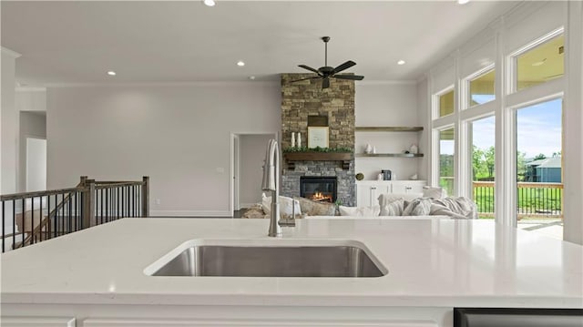 1300 Melissa Ct, Kearney, MO 64060 - kitchen featuring a sink, ceiling fan, ornamental molding, dishwashing machine, and a fireplace