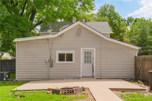9318 Noland Rd, Lenexa, KS 66215 - rear view of house with central air condition unit, a patio, and a chimney