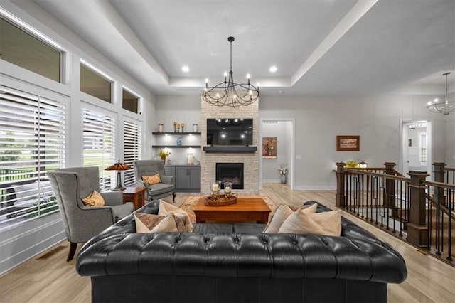 10031 S Lakota St, Olathe, KS 66061 - living area with a chandelier, a raised ceiling, light wood-style floors, a fireplace, and recessed lighting