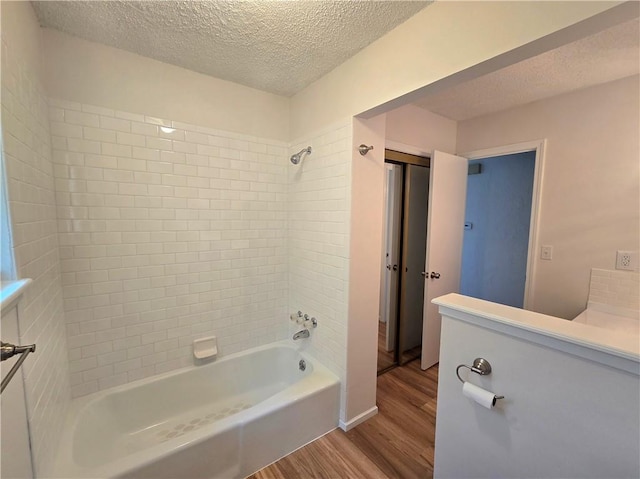 1506 N Holland Ct, Independence, MO 64056 - bathroom featuring wood finished floors, a textured ceiling, washtub / shower combination, and vanity