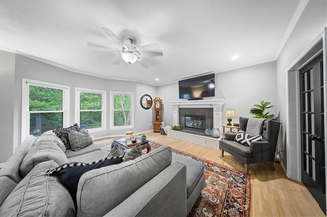 8102 W 153rd St, Overland Park, KS 66223 - living room featuring wood finished floors, ceiling fan, ornamental molding, a glass covered fireplace, and recessed lighting