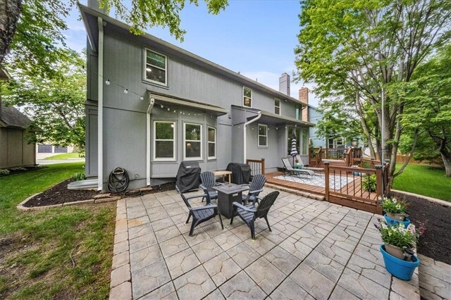 8102 W 153rd St, Overland Park, KS 66223 - rear view of house with a deck, a patio, and a chimney
