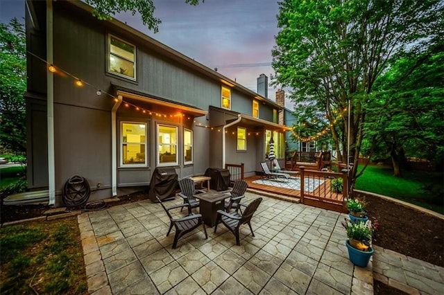 8102 W 153rd St, Overland Park, KS 66223 - patio terrace at dusk featuring a patio and a wooden deck