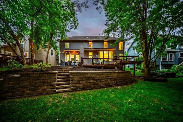 8102 W 153rd St, Overland Park, KS 66223 - back of house at dusk with a lawn, a wooden deck, and stucco siding