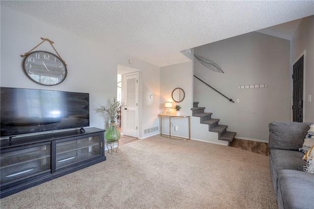 2406 Alabama St Unit 9D, Lawrence, KS 66046 - carpeted living area featuring stairs and a textured ceiling
