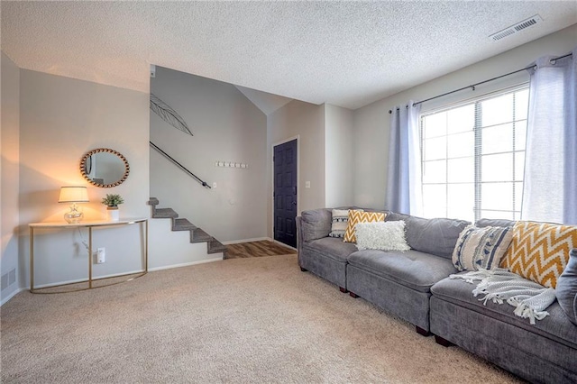 2406 Alabama St Unit 9D, Lawrence, KS 66046 - living room featuring carpet flooring, stairway, and a textured ceiling