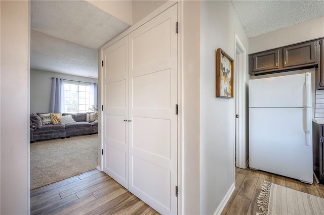 2406 Alabama St Unit 9D, Lawrence, KS 66046 - corridor with a textured ceiling and light wood-style floors