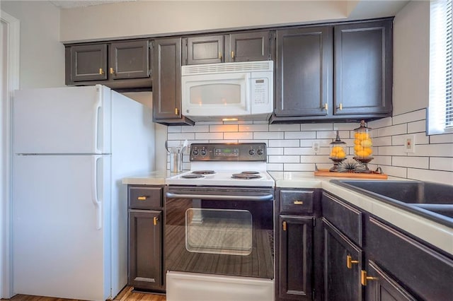 2406 Alabama St Unit 9D, Lawrence, KS 66046 - kitchen featuring white appliances, tasteful backsplash, plenty of natural light, and light countertops