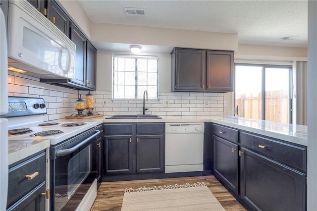 2406 Alabama St Unit 9D, Lawrence, KS 66046 - kitchen with white appliances, light countertops, plenty of natural light, and backsplash